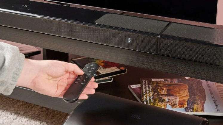 Man using remote on JBL Bar 1300MK2.