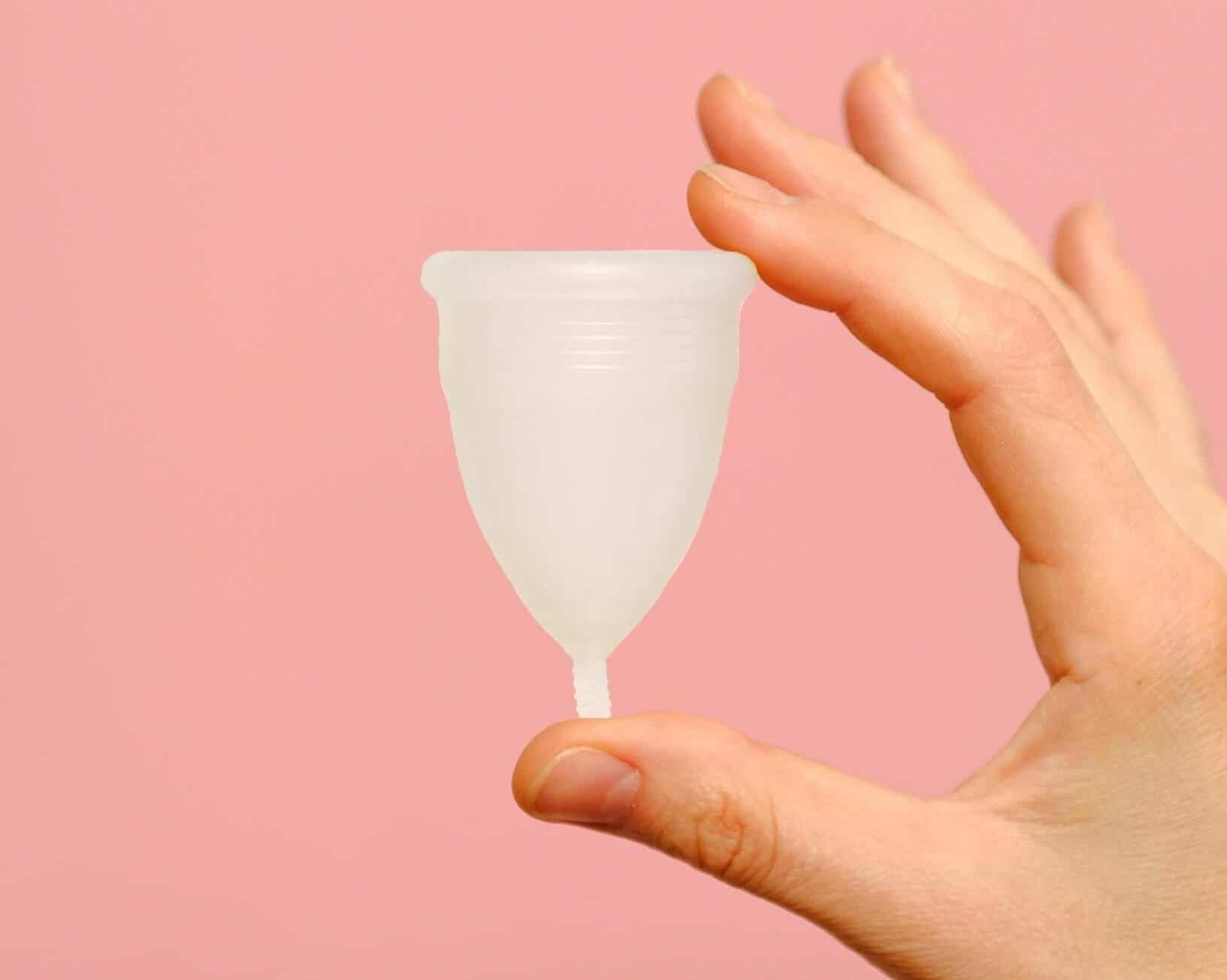 a white diva cup against a pink background