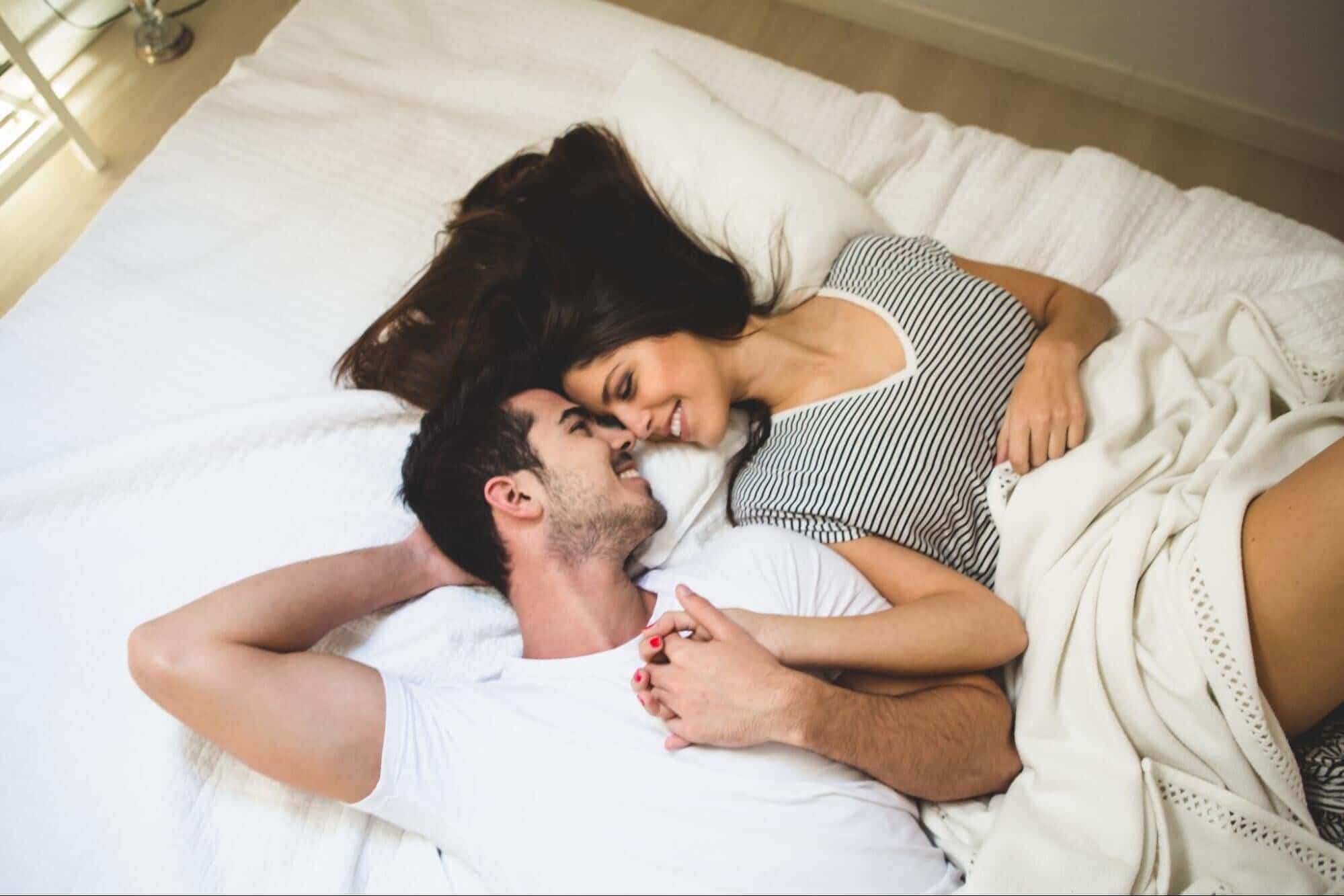 Man and woman cuddling on bed
