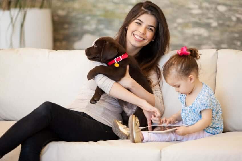 Mom and daughter on couch with first dog