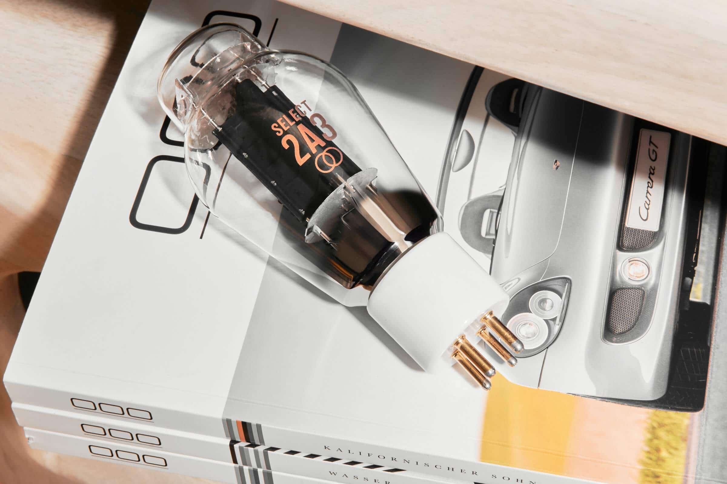 A hand-selected Ray Tubes SELECT 2A3 vacuum tube displayed on a stack of automotive magazines.