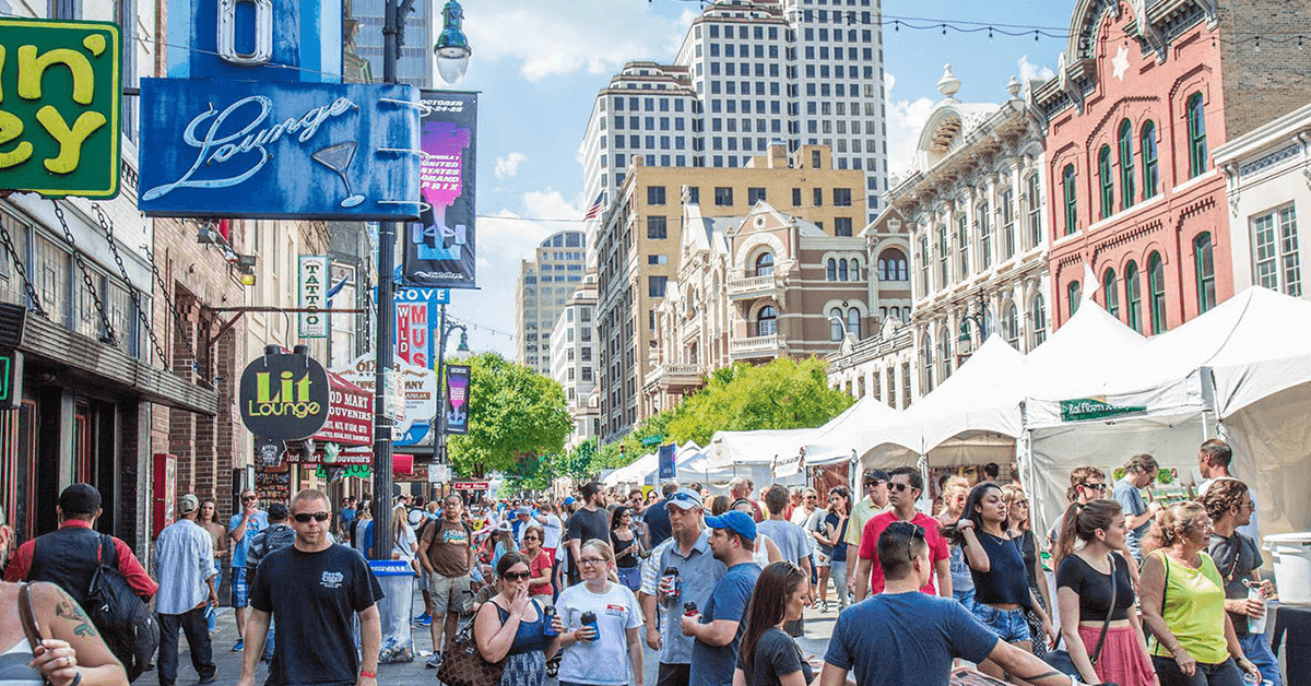 Austin residents walking around a downtown festival with pop-up tents