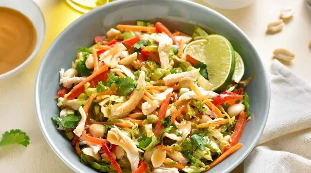 Meal prep containers filled with shredded chicken, grains, and fresh vegetables.