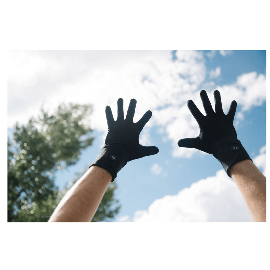 A man hold's up his hands to the sky wearing Toasty Touch Raynaud's gloves