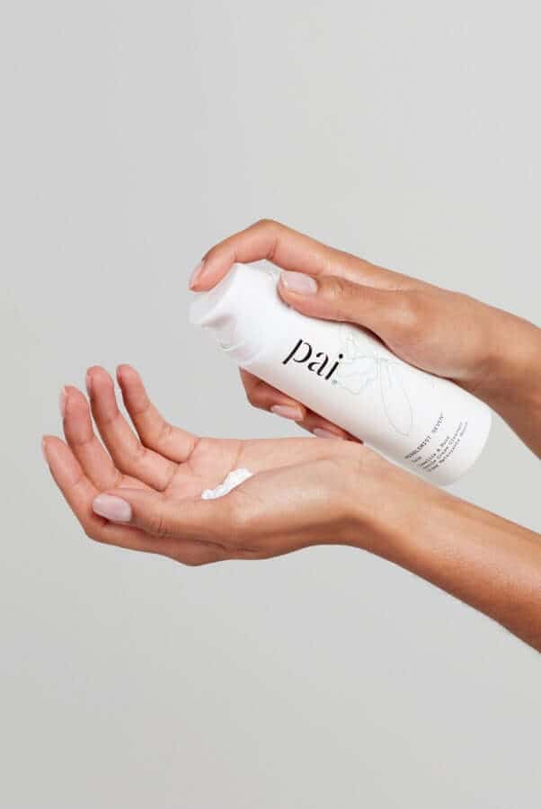 Hands dispensing Middlemist Seven cream cleanser into palm against neutral background